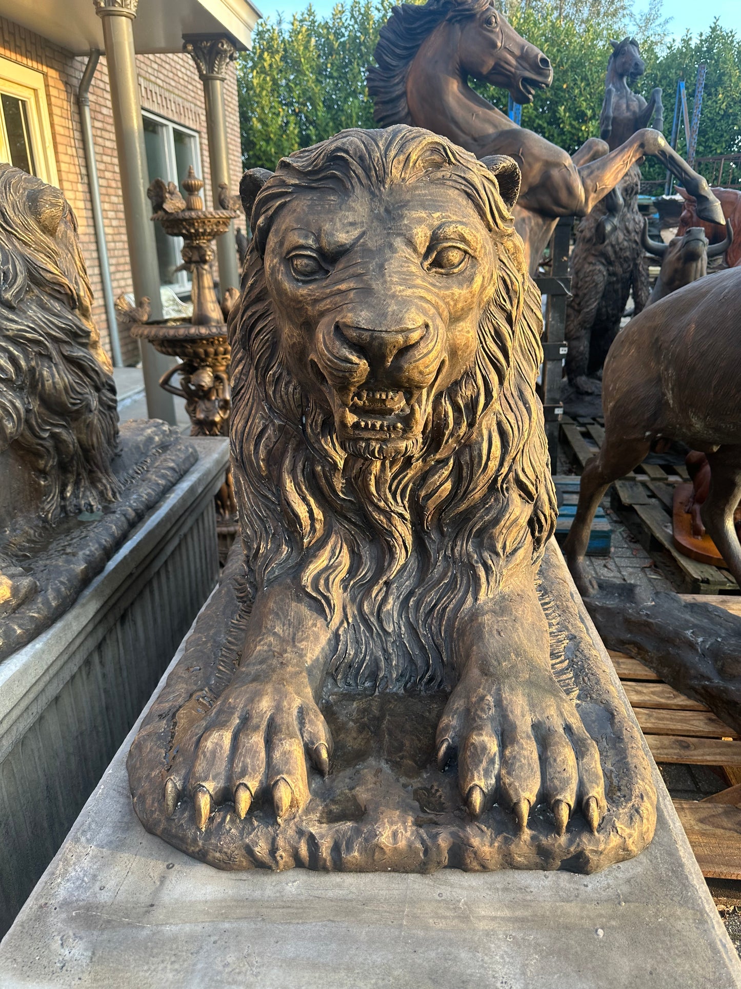 Pair of monumental bronze lions on concrete plinths