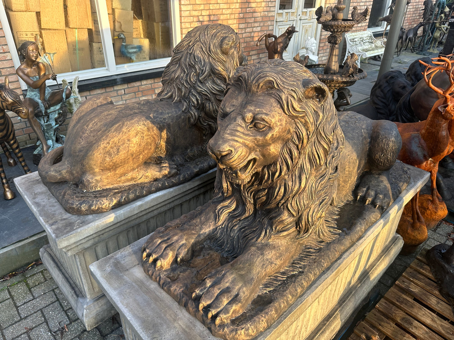 Pair of monumental bronze lions on concrete plinths