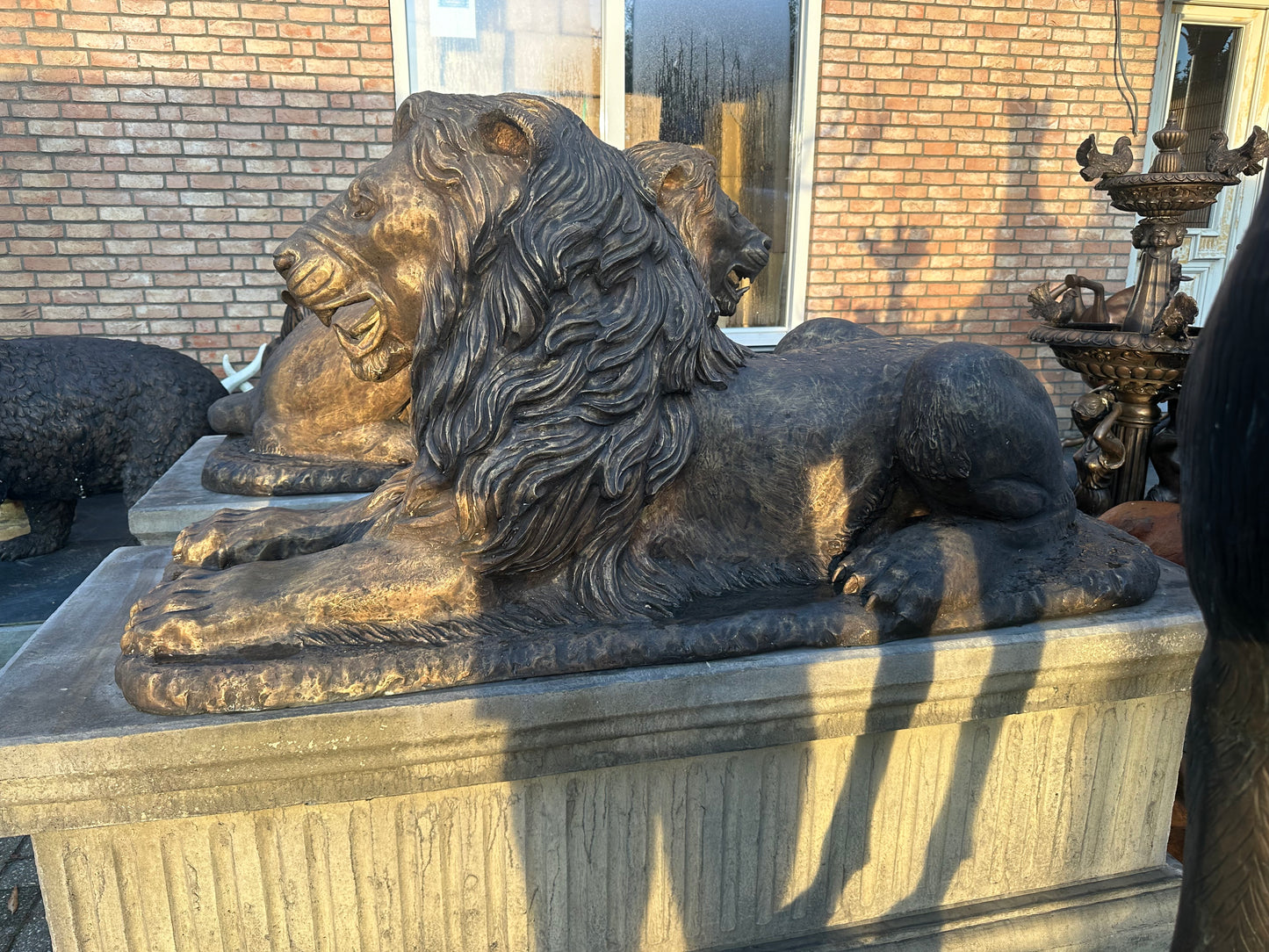 Pair of monumental bronze lions on concrete plinths